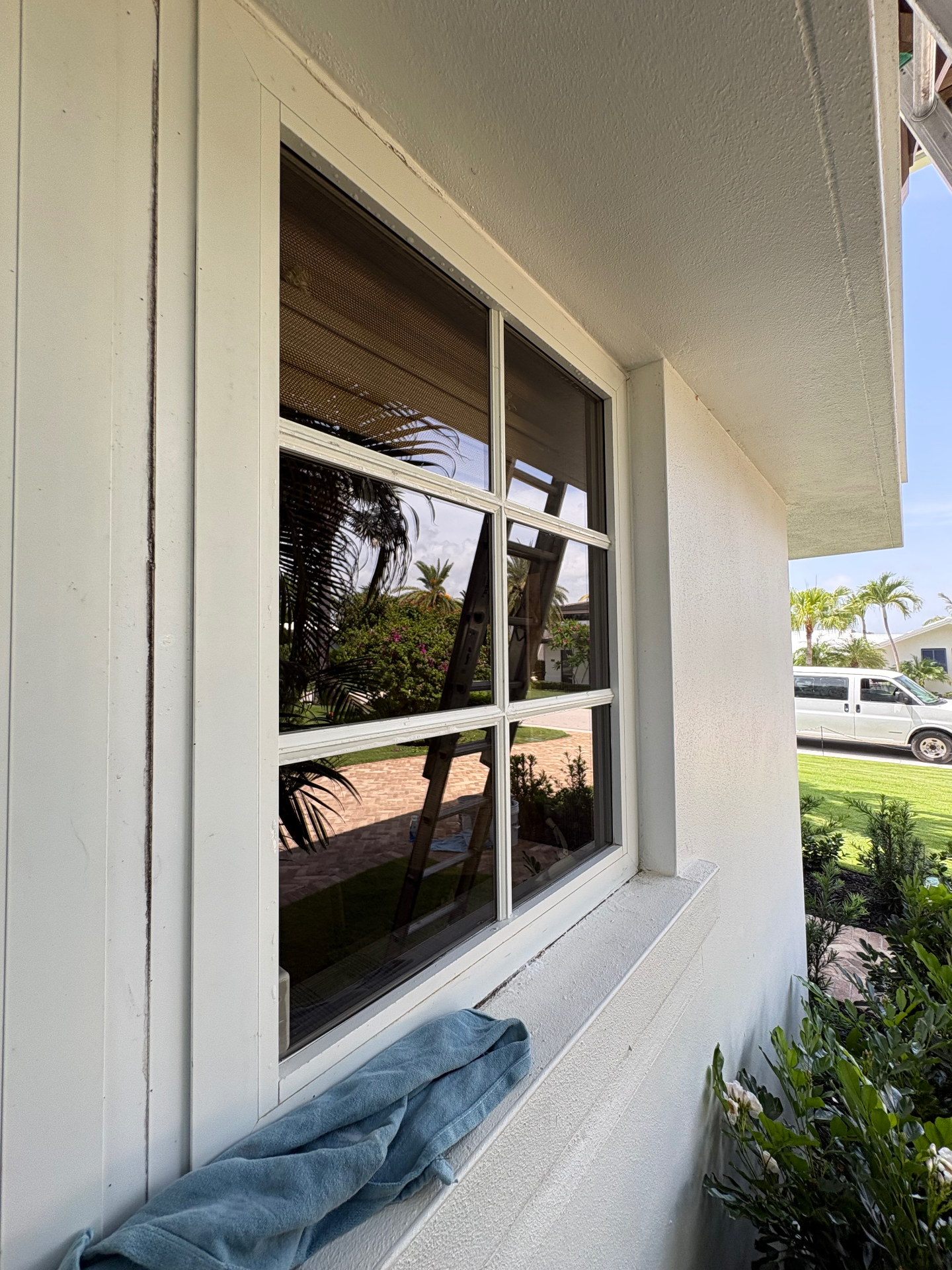 Freshly cleaned exterior window with Pure Panes equipment reflected in the glass